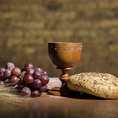 grapes, wheat, bread and wine in a wood table